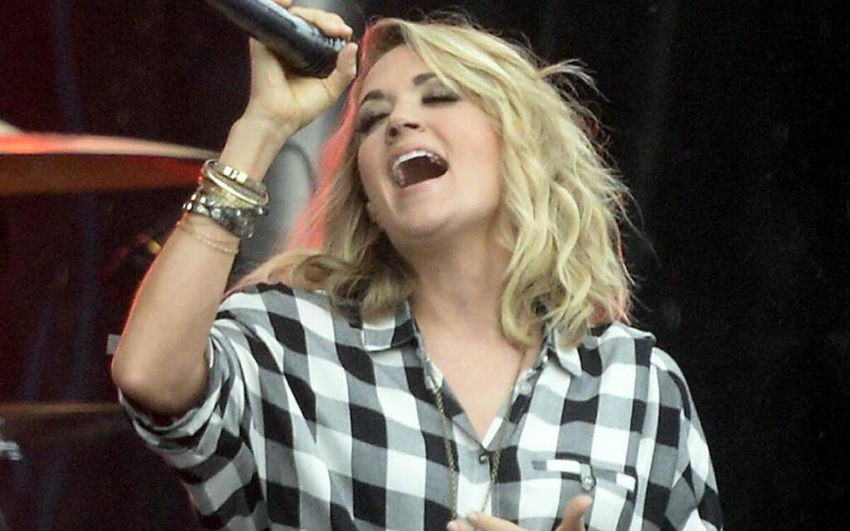 Grammy winning country music star Carrie Underwood performs for rain drenched fans during her concert at the Belk Bowl FanFest outside of Bank of America Stadium on Wednesday, December 30, 2015.
