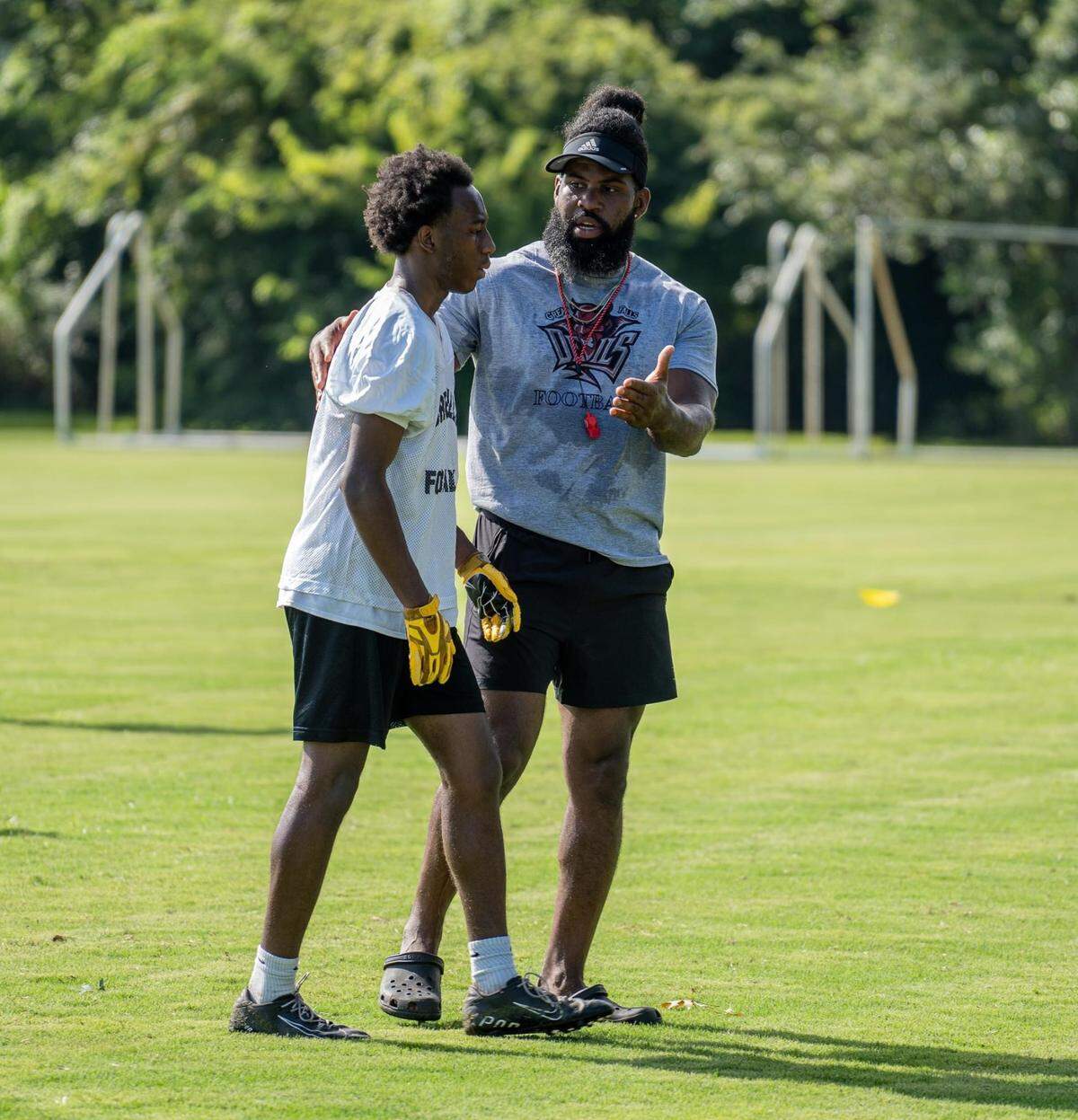 Syvelle Newton speaks with a player during a practice.
