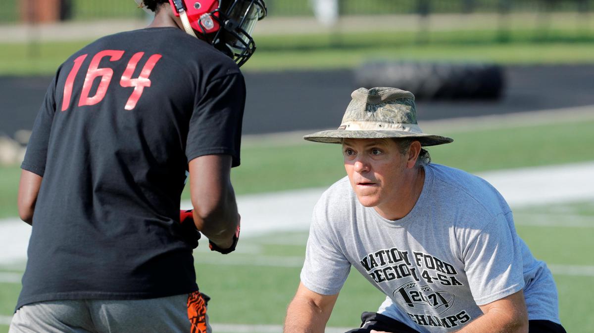 NAFO head coach Michael Allen works with a player as the Falcons took to the practice field for the 2018 season Saturday..