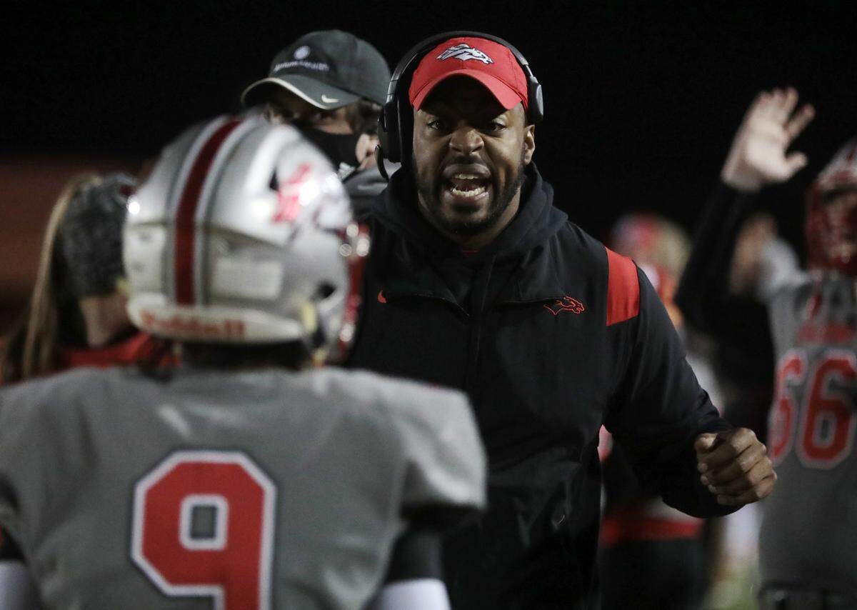 South Pointe varsity football coach DeVonte Holloman encourages Khyre Rawlinson (9) in South Pointe’s semifinal win over Greenville. That win sent the Stallions to the 2021 4A state championship game in Columbia on Thursday night.