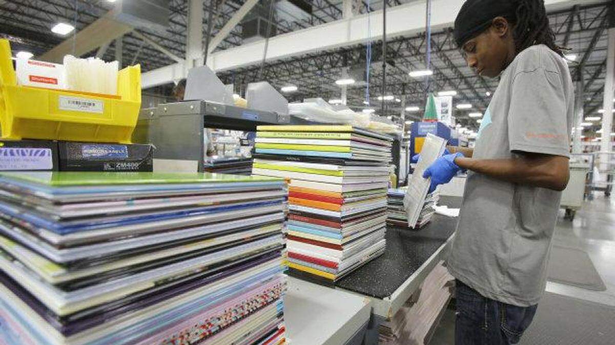 Shutterfly opened its York County operations in Fort Mill in 2013. Shown here, Bridgett Williams examines photo books before they are shipped to customers.