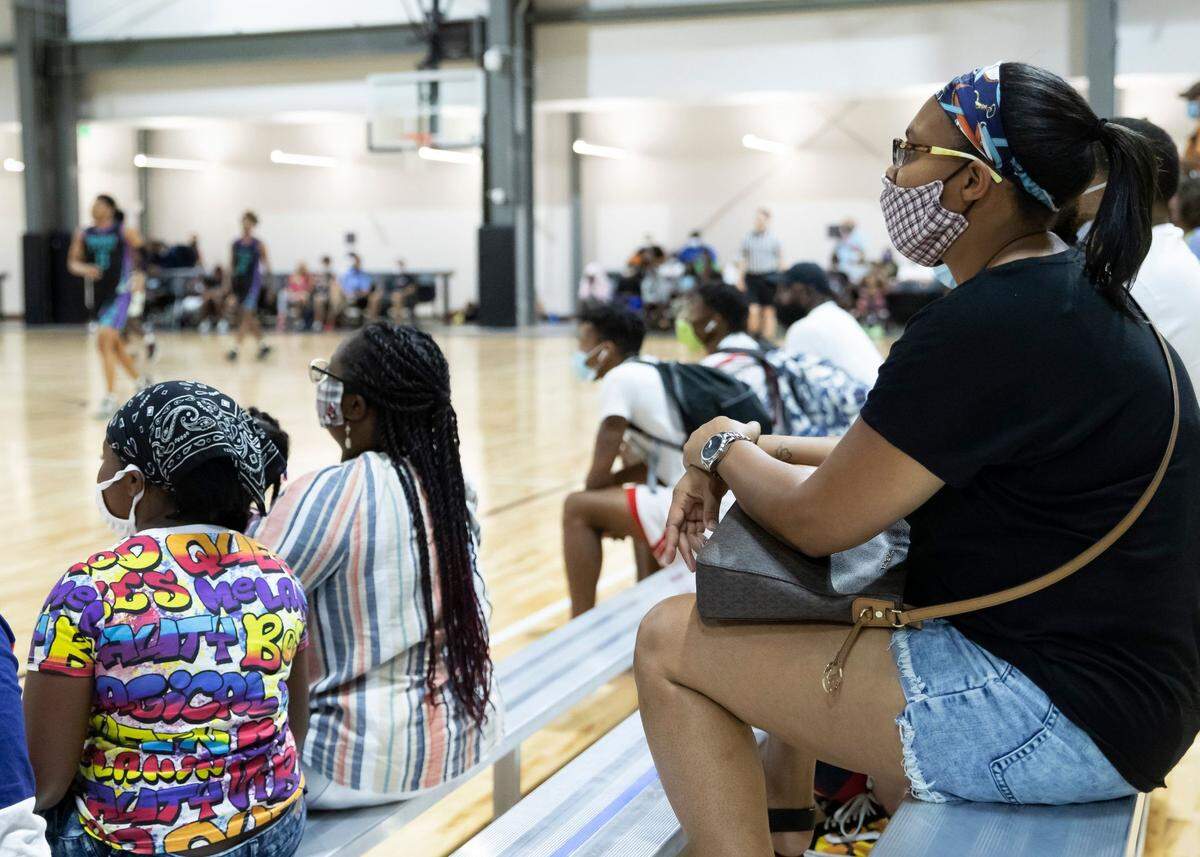 A fan social distances and watches a basketball game with a mask on during a basketball tournament in the Rock Hill Sports and Event Center (July 31-Aug. 2).