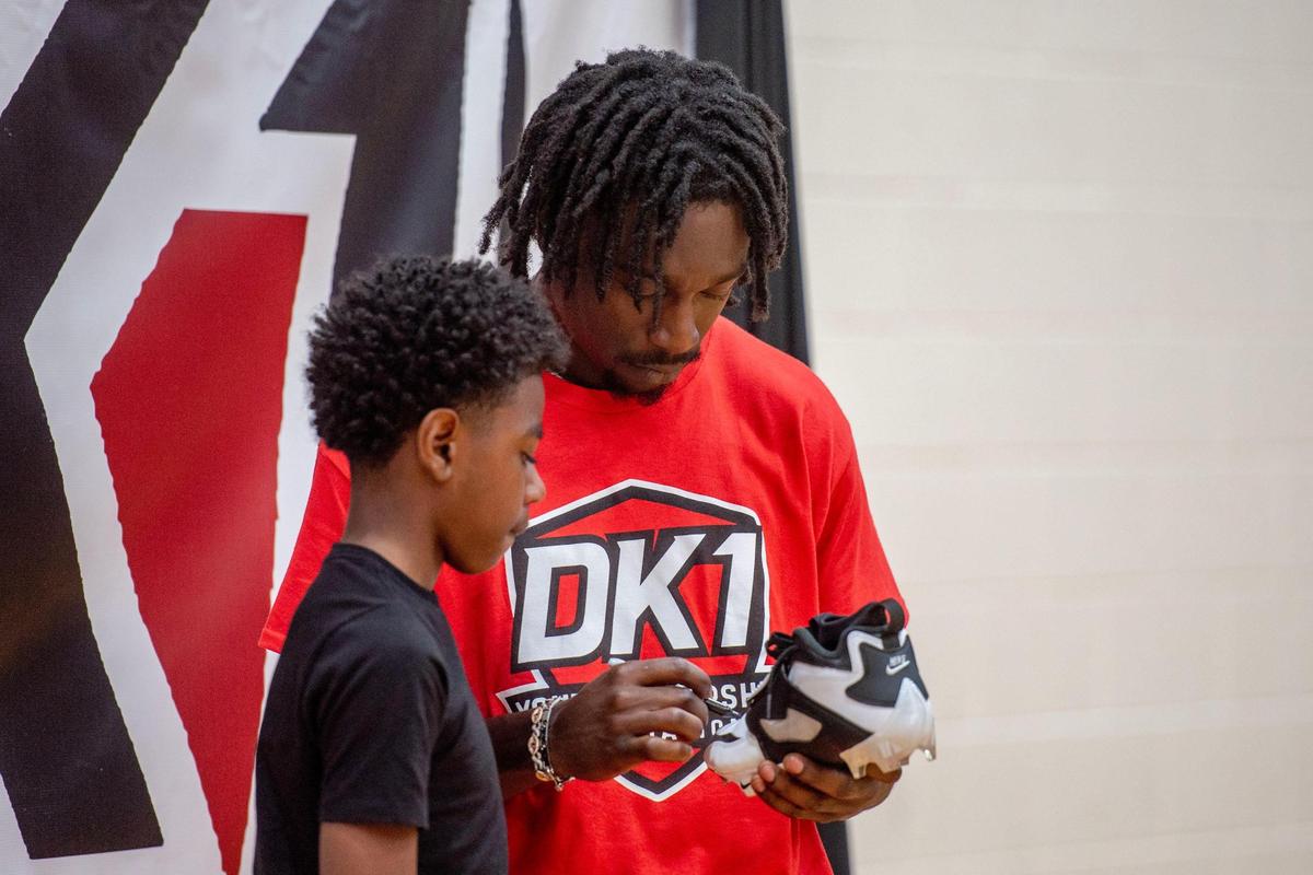 Derion Kendrick, Rams cornerback and South Pointe High School alum, signs Princeton Barber’s cleat during Kendrick’s two-day youth football camp at his alma mater in Rock Hill.