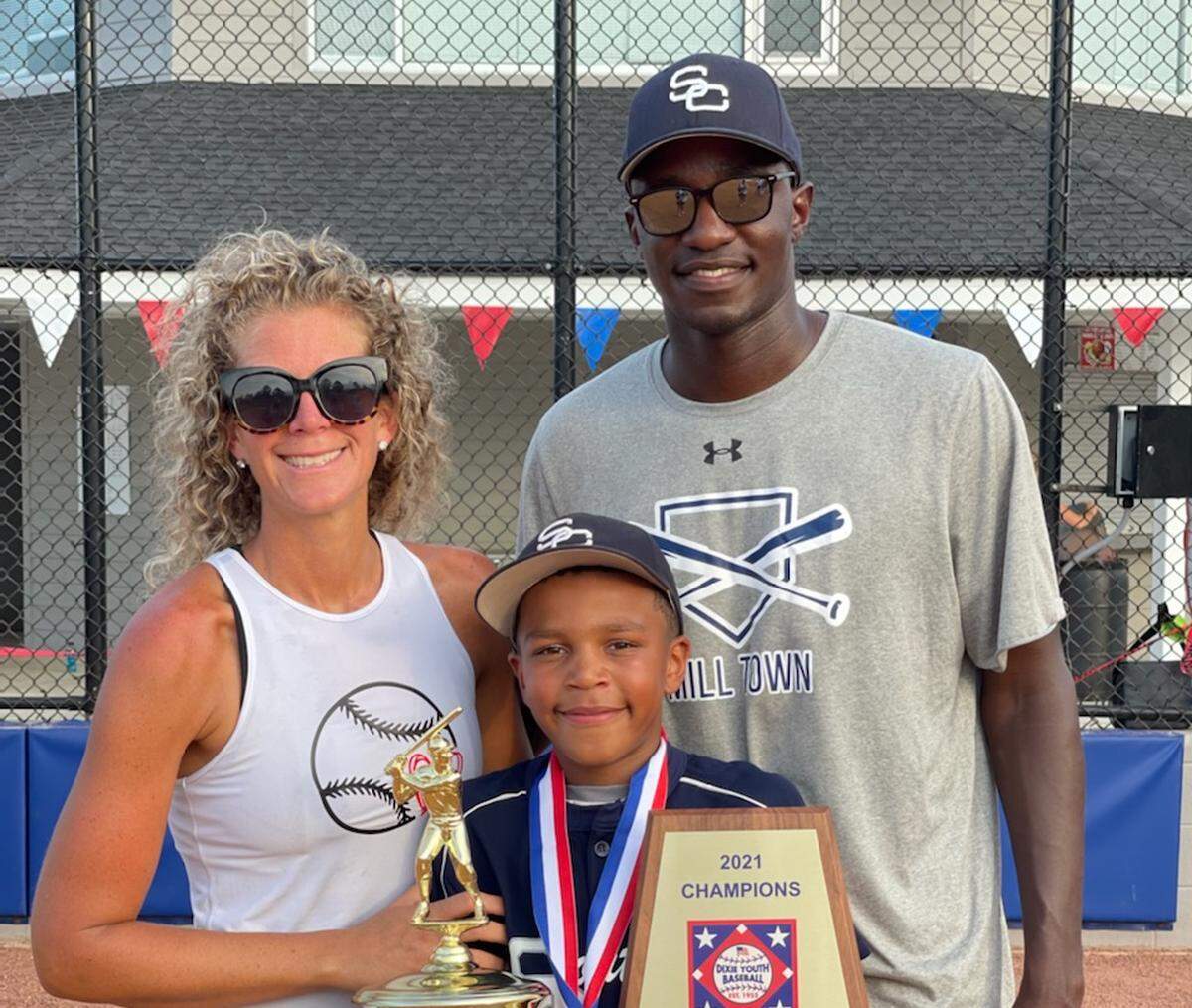 Gordon Owino holding the trophy with his mother, Hayley, and his father, Arnold.