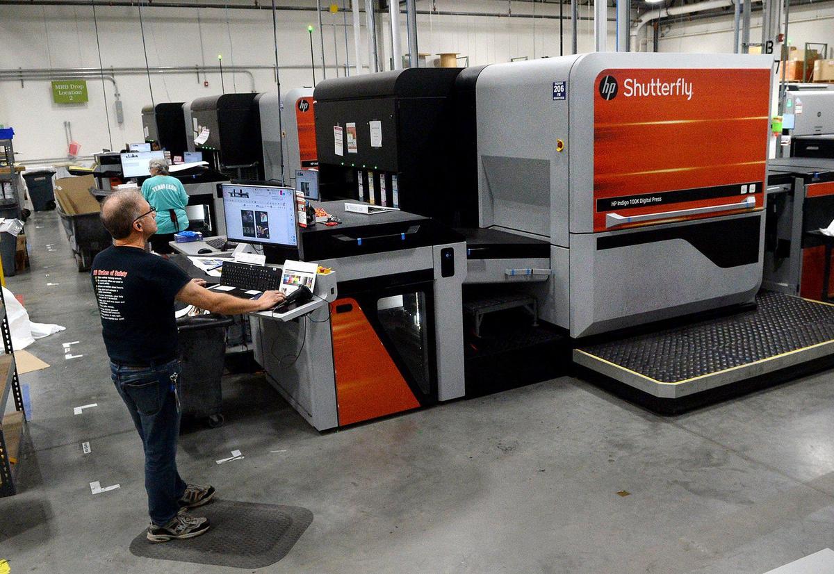 Carl Proia, a digital press operator, adjusts the settings on a sheet for a photo book at Shutterfly in Fort Mill, S.C.