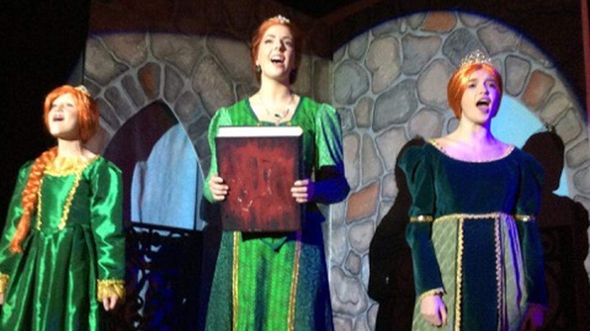 Young Fiona, Natalie DiStasio; Fiona, Anna Cibbarellie and Teen Fiona, Skylar Huntly rehearse “I Know It’s Today” as they dream of their rescue by a handsome prince in Rock Hill Community Theatre’s production of Shrek The Musical TYA. Performances will be Aug. 2-5 and  10-12. Matinees will be on Sundays at the theatre on Cherry Road.