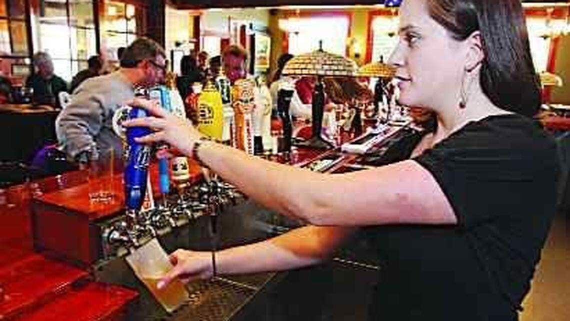 Bartender Amy Pusateri draws a beer for a customer at The Six Pence Pub.