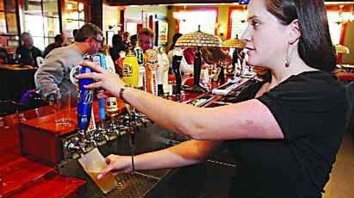 Bartender Amy Pusateri draws a beer for a customer at The Six Pence Pub.