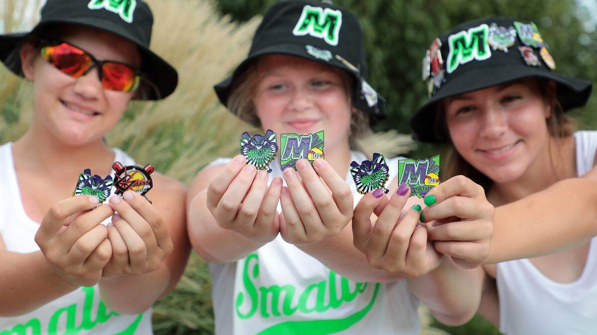Ohio Monsters softball team members, from left, Adrianna Buchanan, Brooklyn Prince and Stephanie Moraz hold pins from their team and other teams Friday at the National Softball Association’s Fastpitch World Series kickoff event at Fountain Park.