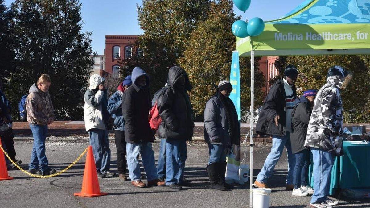 Clients line up in the parking lot of Renew Our Community in Rock Hill in 2018 to receive free blankets and gloves.
