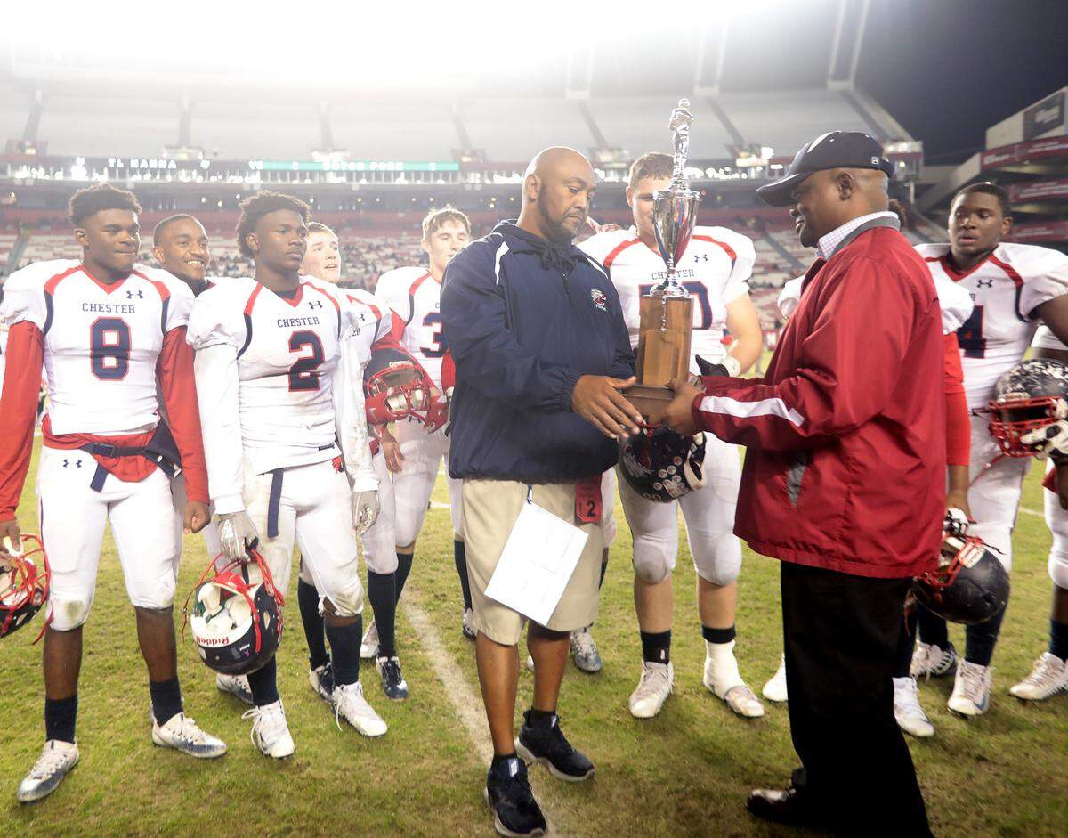Chester varsity football coach Victor Floyd receives the state championship trophy Friday at Williams-Brice Stadium in Columbia.