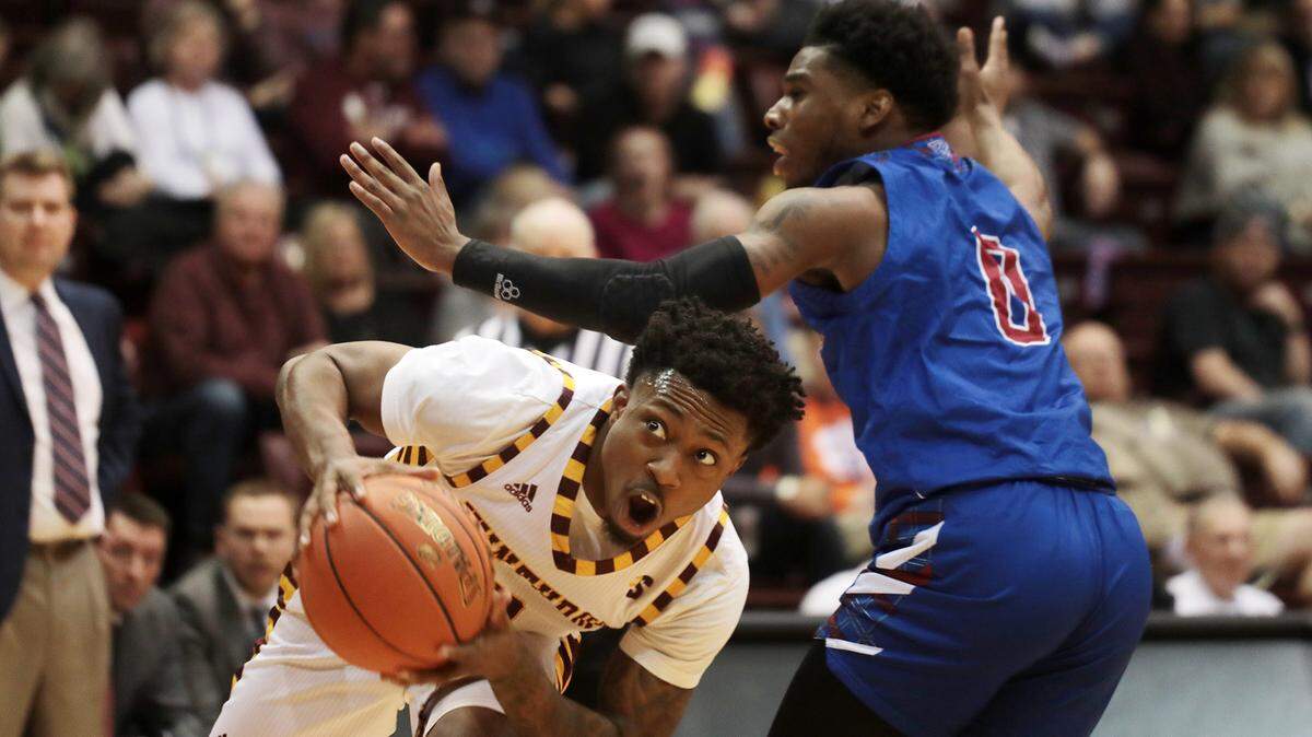 Winthrop’s Nych Smith heads to the basket around Presbyterian’s Chris Martin.