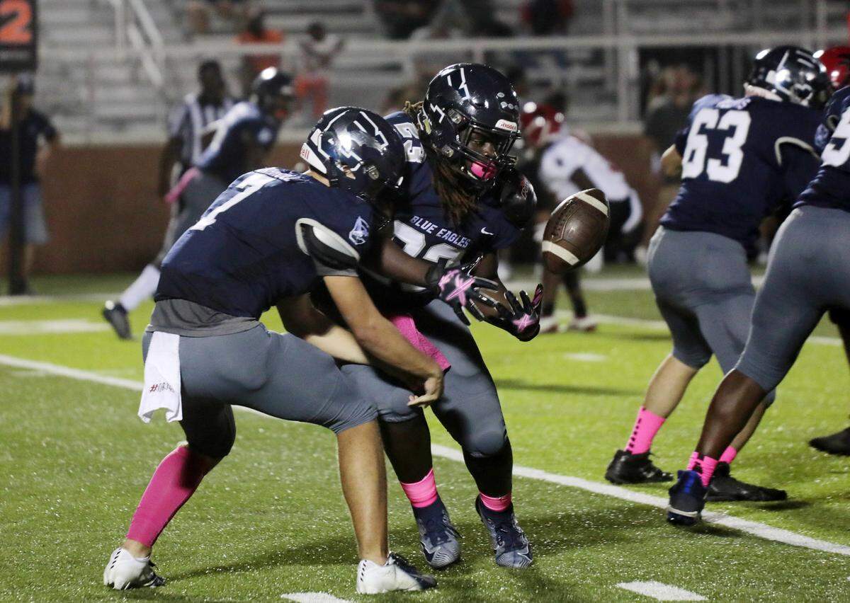 Clover’s David Hall (23) struggles to hold onto the ball next to Gabe Carroll (7) Friday as the Blue Eagles compete with the Nation Ford Falcons in Clover.
