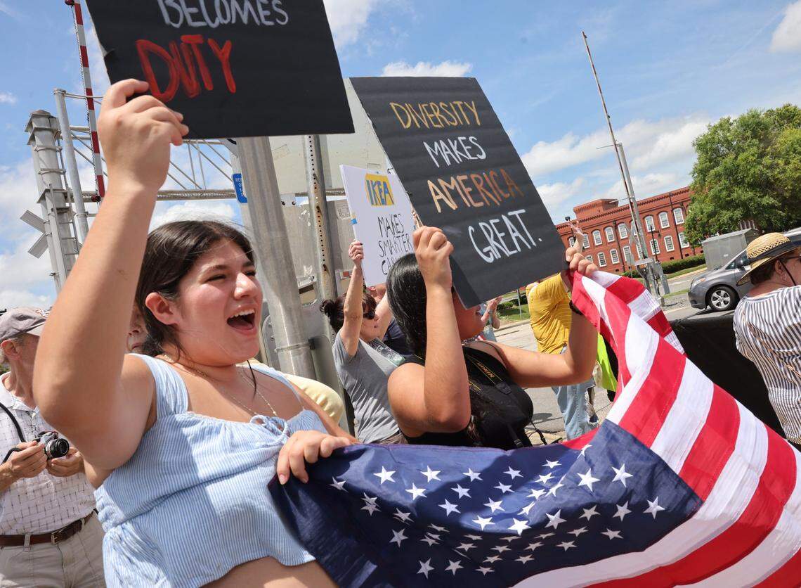 Amy Visoso, left, and Jessica Visoso hold signs and an American flag during the ‘No Kings’ protest against President Trump Saturday, June 14, 2025 in Rock Hill, S.C.