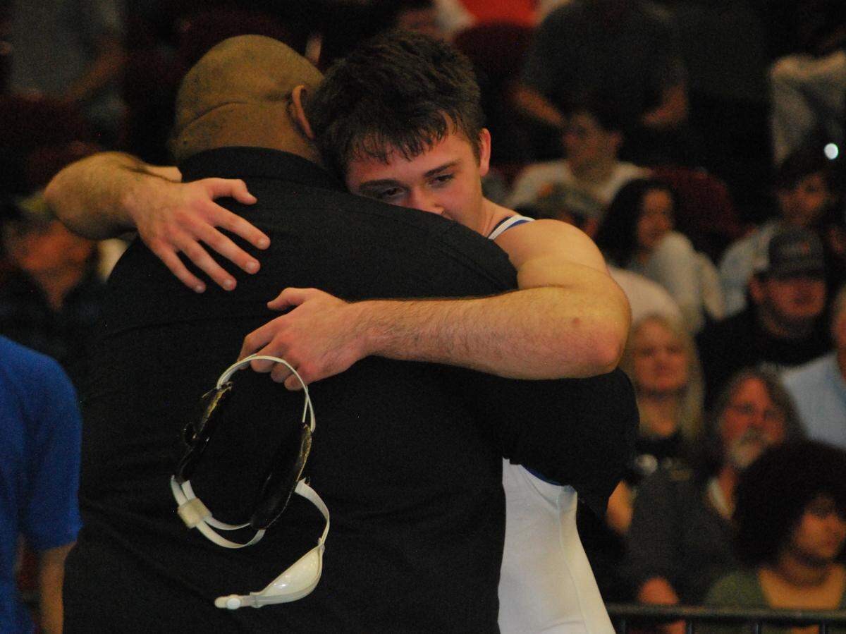 Indian Land wrestler Xavier Dreese hugs head coach Leon Boulware after winning a state championship at 170-pounds at the 2020 individual state tournament.