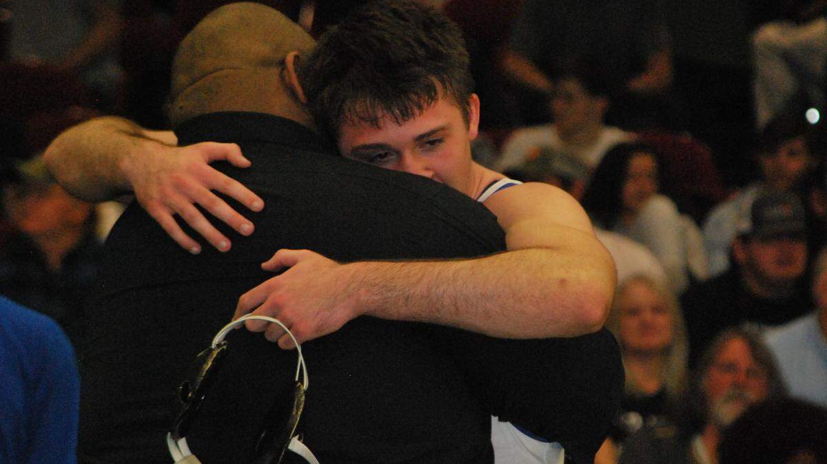 Indian Land wrestler Xavier Dreese hugs head coach Leon Boulware after winning a state championship at 170-pounds.