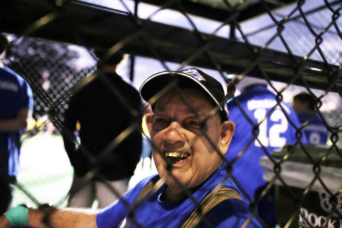 Larry Ferguson, 80, peeks out at a friend during the Miracle League baseball game on Wednesday.
