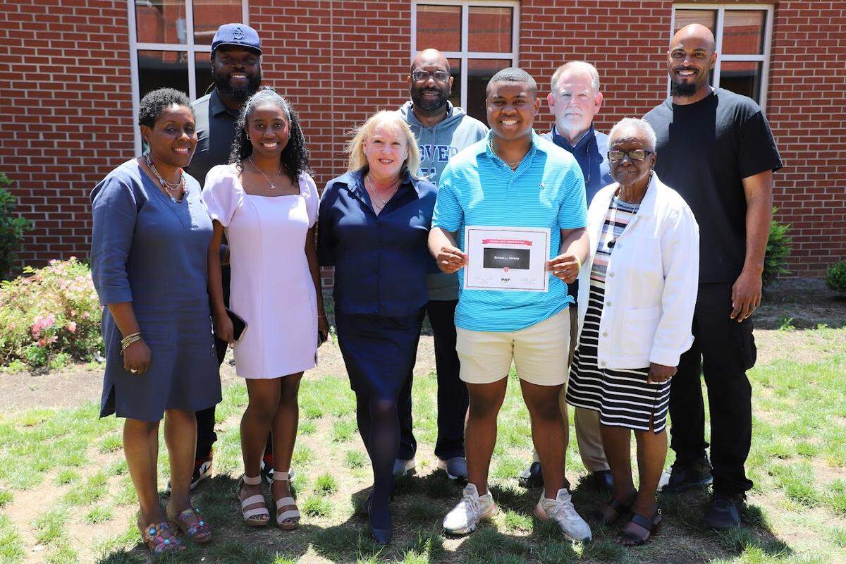 EL Dickey poses for a picture with his family, his coaches and the members of the NFL Players Association that delivered him the scholarship on Tuesday, May 10, 2022. Top row (from left to right): Colin Cole, Brian Lane, Steve Churm, Marques Murrell. Bottom row (from left to right): Millicent Dickey, Erin Dickey, Liz Benavides, EL Dickey, Amarintha Whitener.
