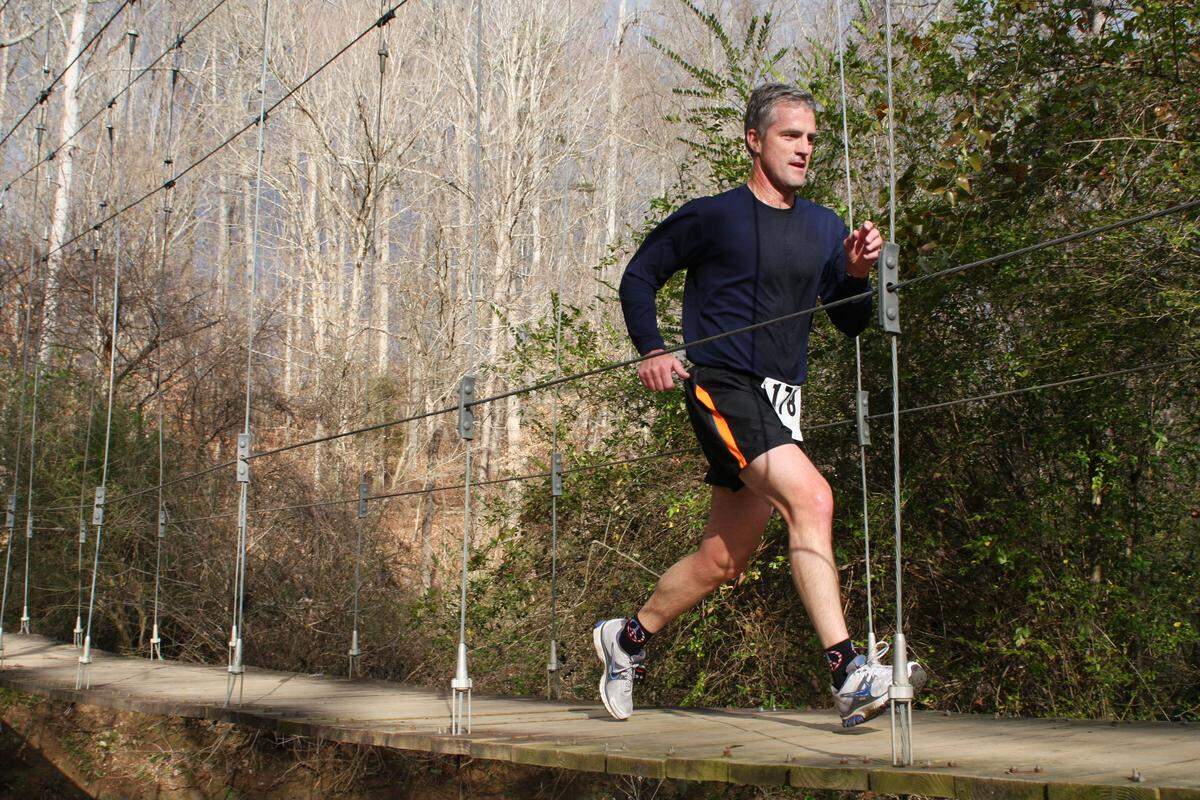 A runner on a suspension bridge at Anne Springs Close Greenway in Fort Mill, S.C.