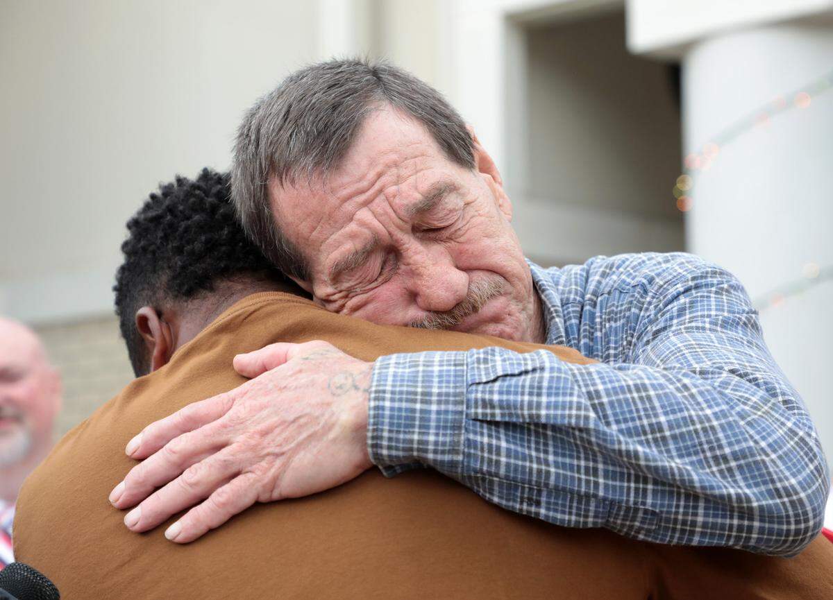 Vernon Robinson, right, hugs Elliot Middleton of Middleton’s Village to Village Foundation after Robinson receives a free car.