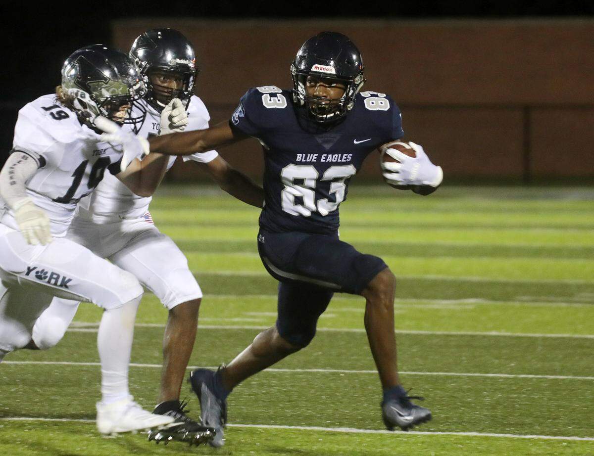 Clover’s Jaylin Lane carries the ball against York’s Ashton Edington (19).