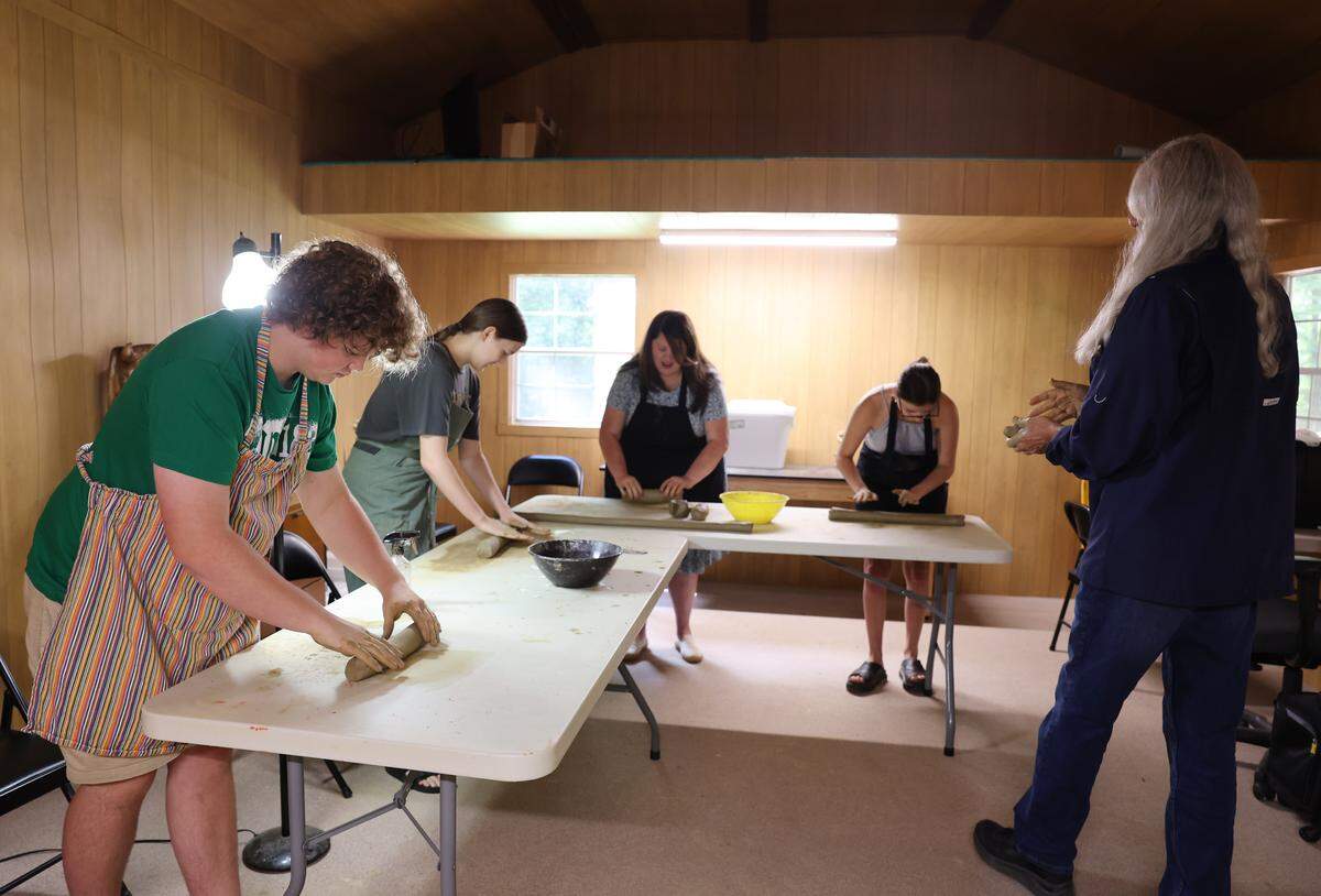 Former Catawba Indian Chief Bill Harris, right, teaches a pottery class Wednesday, July 30, 2025 at the reservation in Rock Hill. Students, from left, are Kenneth Harris, Maddison Totherow, Elizabeth Harris and Sierra Cauthen.