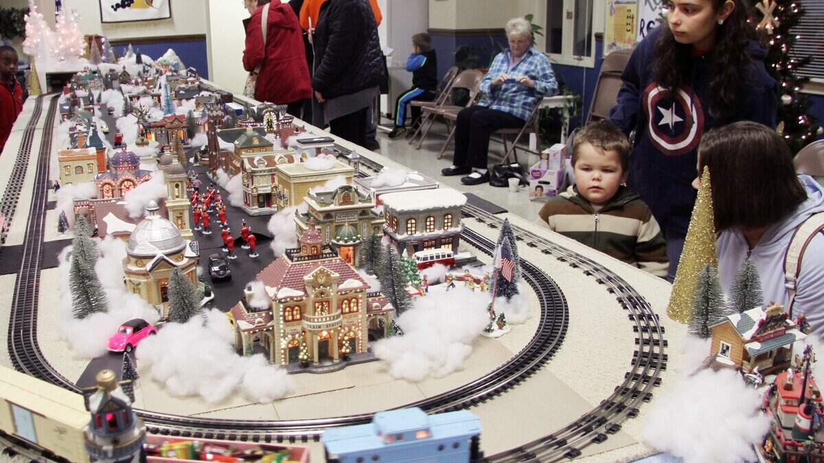 Families look at a miniature train set Friday at Abiding Presence Lutheran Church in York. The church displays the train each year to raise money for charity.