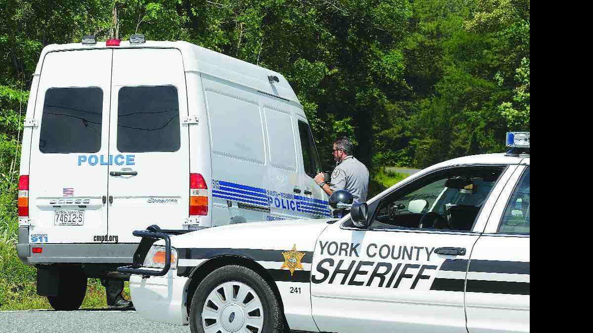 A York County Sheriff's deputy talks to a Charlotte Mecklenburg police officer at the intersection of Vista and Pleasant roads Tuesday.