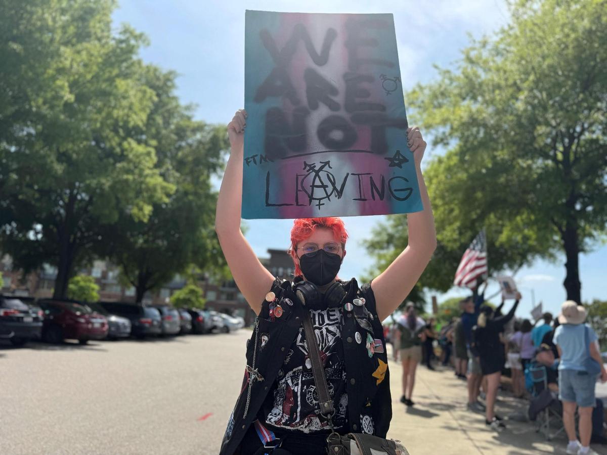 A demonstrator holds a sign Saturday at the York County Rising protest in downtown Rock Hill.