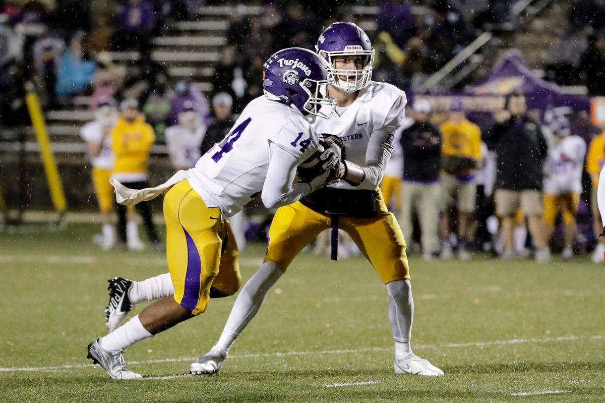 Northwestern’s (14) Turbbo Richard takes the handoff on the wat to another Trojan touchdown as Northwestern takes on Rock Hill in Friday night varsity football action, 10-29-2021.