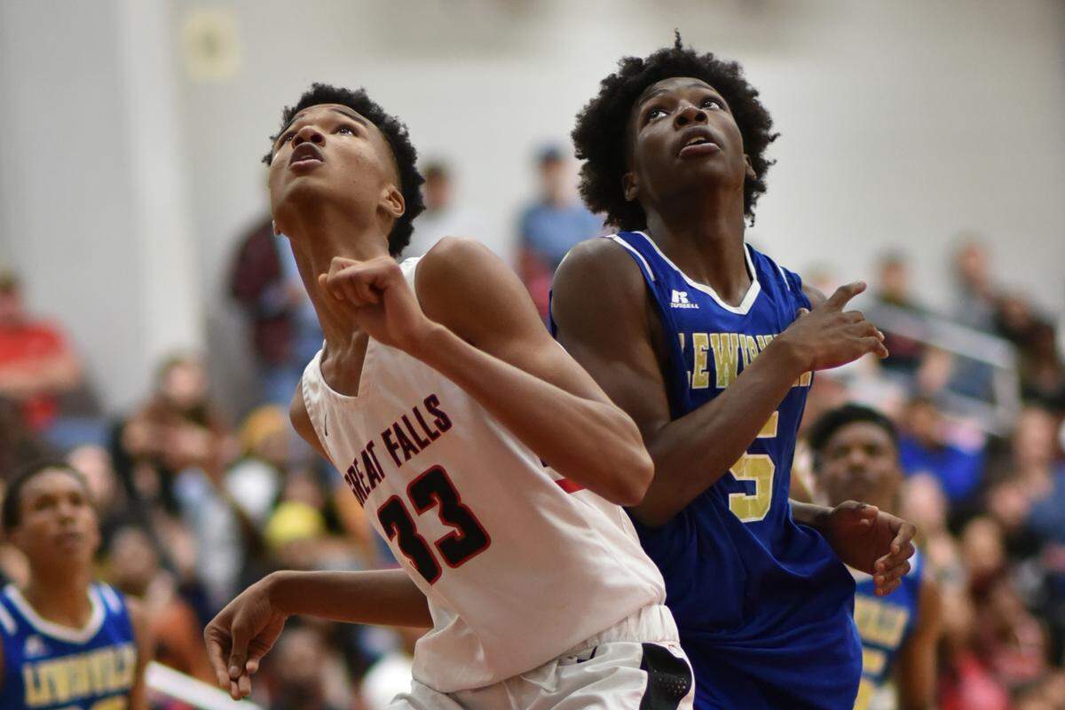 Great Falls’ Tydreiz Colemman and Lewisville’s Jaylen Clyburn anticipate a rebound during Tuesday night’s game at Great Falls. The Red Devils defeated the Lions 67-55.