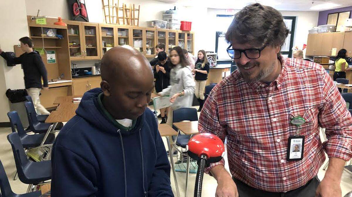 Joe Brandt, a seventh grade teacher at Dutchman Creek Middle School, works with a student.
