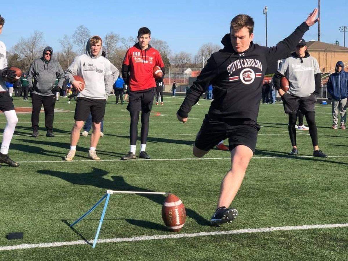 Will Ross, a redshirt freshman for UofSC, kicks for kids at a demo camp earlier this year.