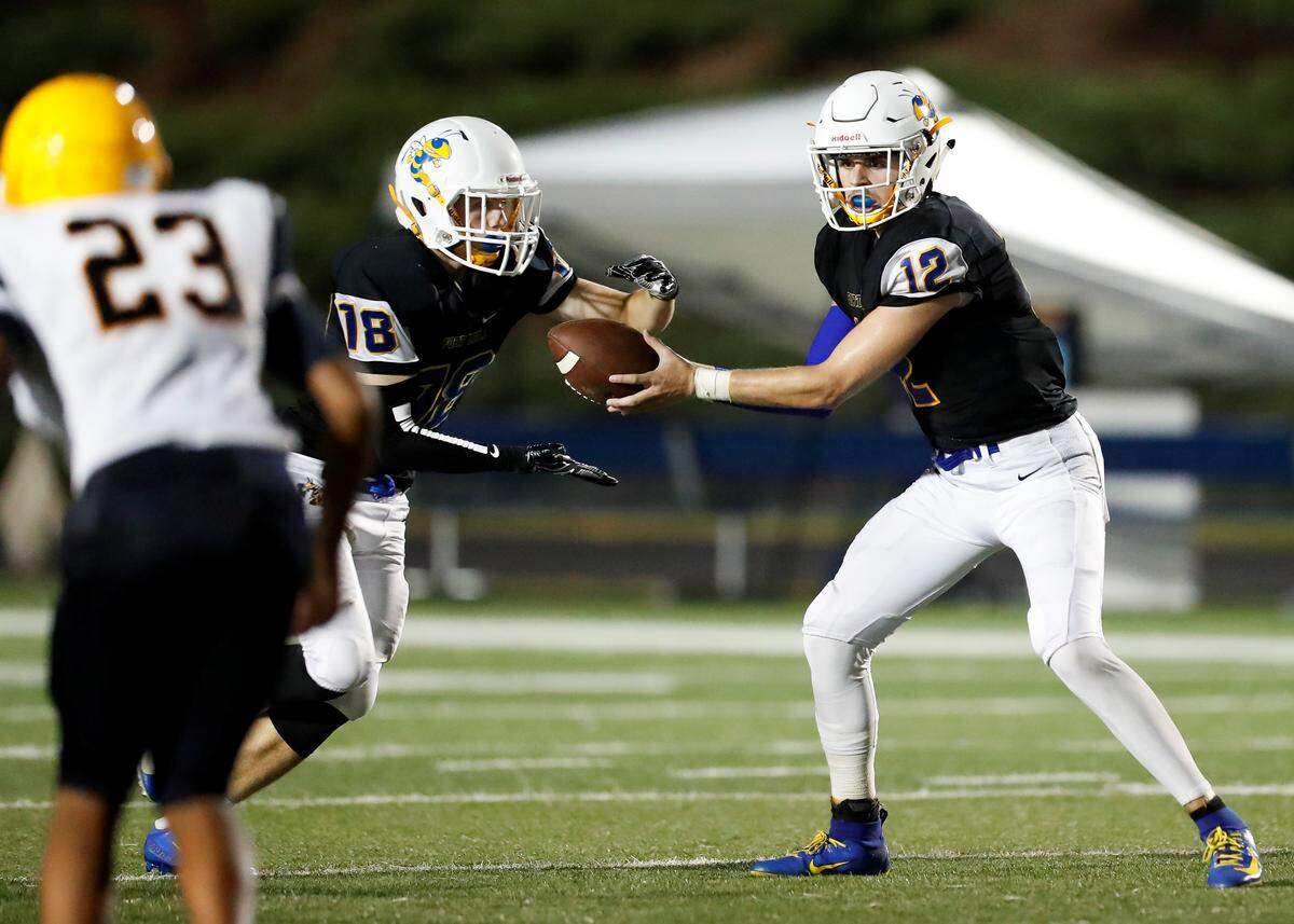 Fort Mill’s #18 Liam Walsh takes the handoff from quarterback #12 Dylan Helms as Fort Mill hosts Lancaster in non-conference varsity football action Friday September 6th 2019.