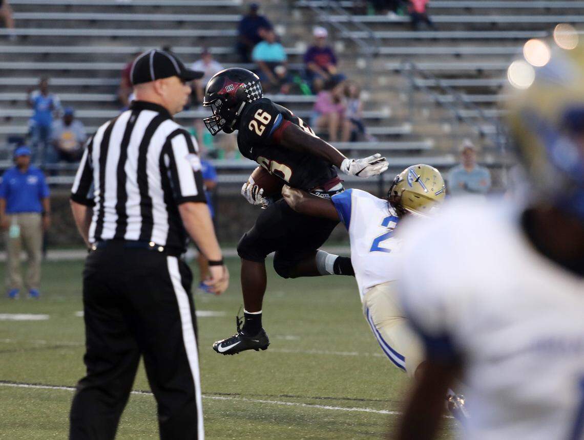 Rock Hill’s Narii Gaither, left, is brought down by Indian Land’s David Mwakapusya.
