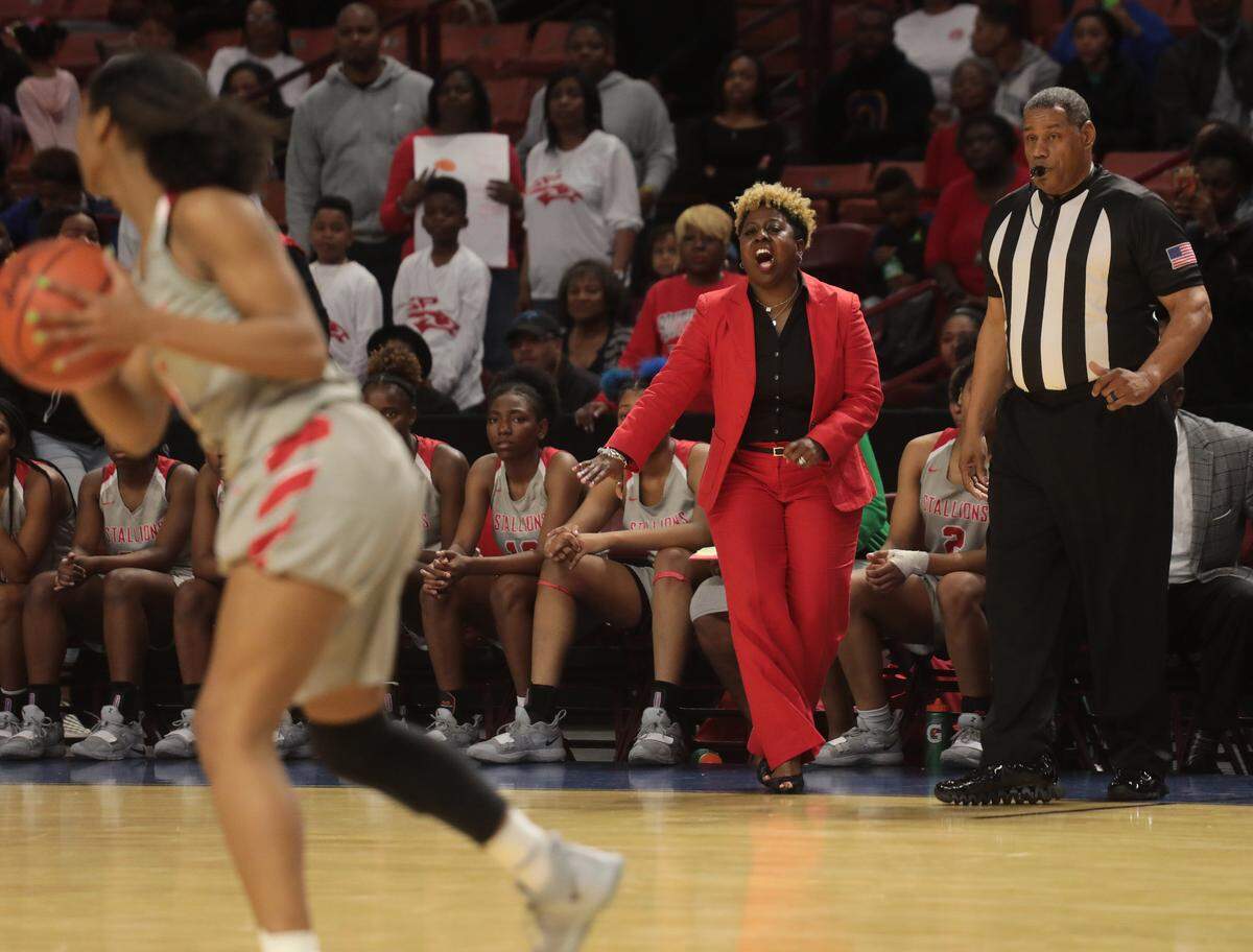 South Pointe High School varsity girls basketball coach Stephanie Butler cheers for the team Friday in Greenville.