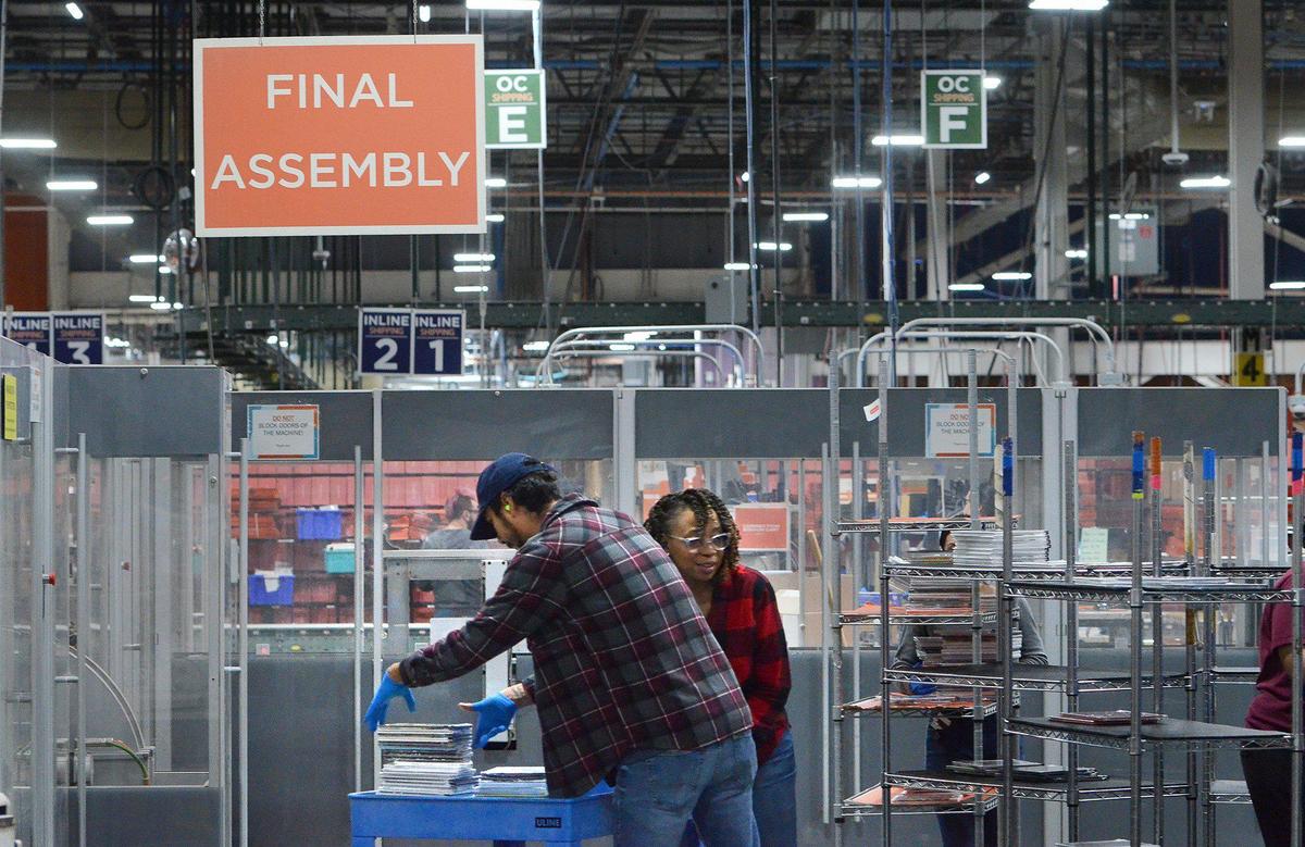 Francisco Berumen (left) sorts finished photo books before packaging and shipping at Shutterfly.