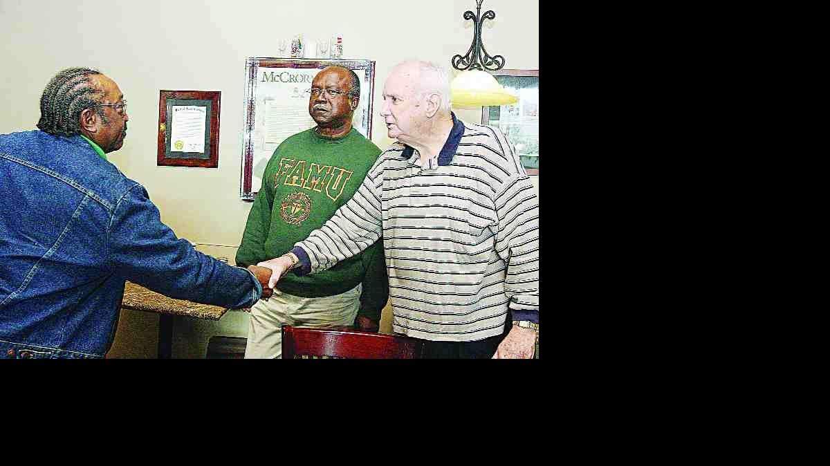 Friendship Nine members Willie McCleod, left, and David Williamson, center, talk with Elwin Wilson at Old Town Bistro in downtown Rock Hill on Friday. Wilson came to the restaurant to apologize for his years of racial hatred.
