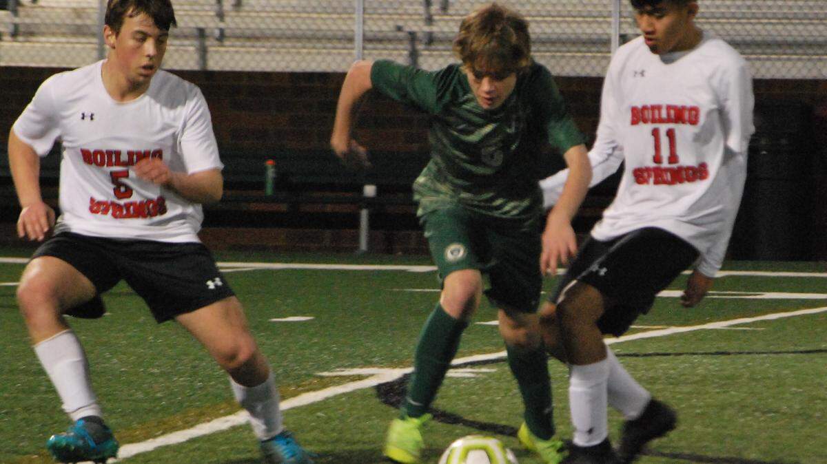 Catawba Ridge’s Joshua White, center, battles for the ball between two Boiling Springs defenders during the Copperheads first home soccer match.