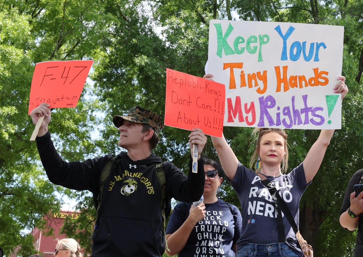 Erik Barnette, left, and Jessica Milicevic holds signs toward Dave Lyle Blvd. Saturday at the York County Rising anti-Trump demonstration.