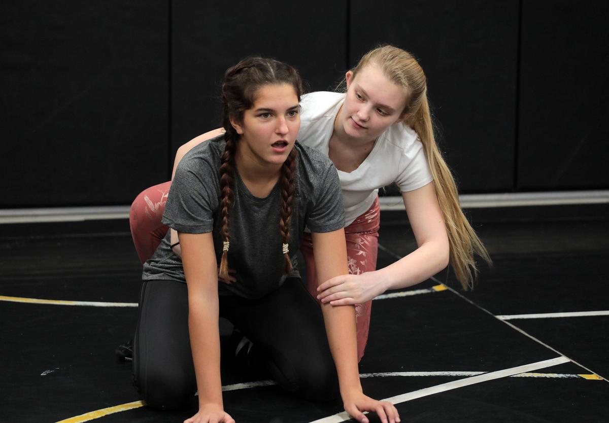 14-year-old Cyan Smith, left, and 17-year-old Samantha Neff attend wrestling practice at Rock Hill High School.