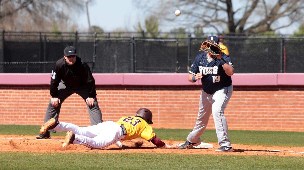 Winthrop’s Brandon Fite slides back into first base as Charleston Southern’s Ryan Stoudemire waits for the ball.