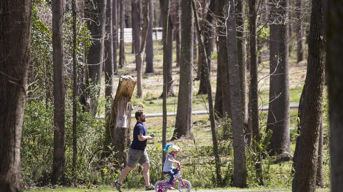 A runner and a little girl take advantage of the mild weather to exercise at Riverwalk in Rock Hill, S.C.
