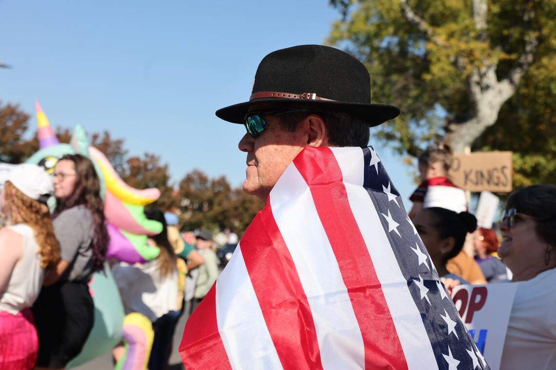 A protester is wrapped in an American flag Saturday at the Rock Hill ‘No Kings’ rally downtown.