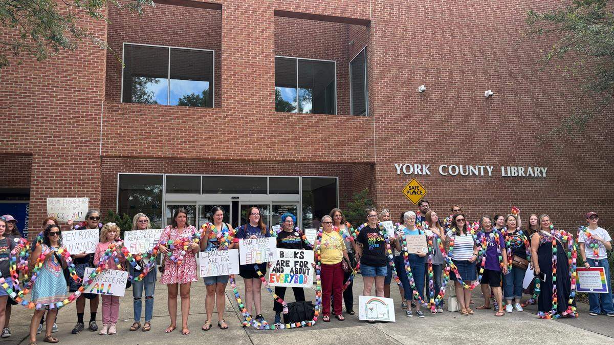 York County residents hold a paper chain outside the library Thursday. Each link represents a signature on a petition opposing a proposed anti-LGBTQ book policy.