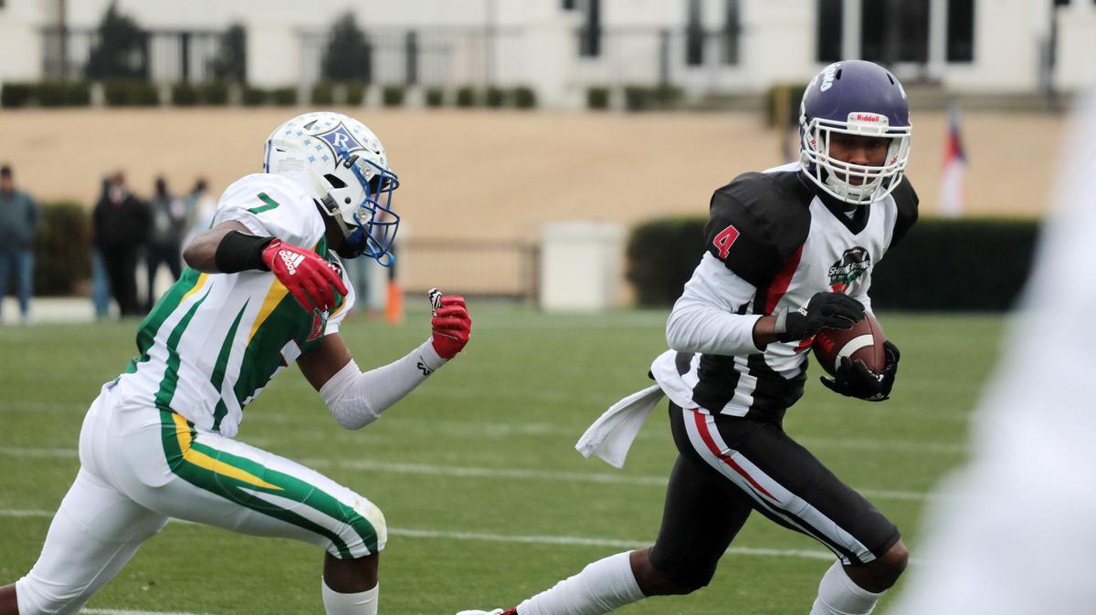 South Carolina’s Ger-Cari Caldwell of Northwestern High School carries the ball against North Carolina’s Devan Boykin of Ragsdale High School Saturday at the Shrine Bowl in Spartanburg.