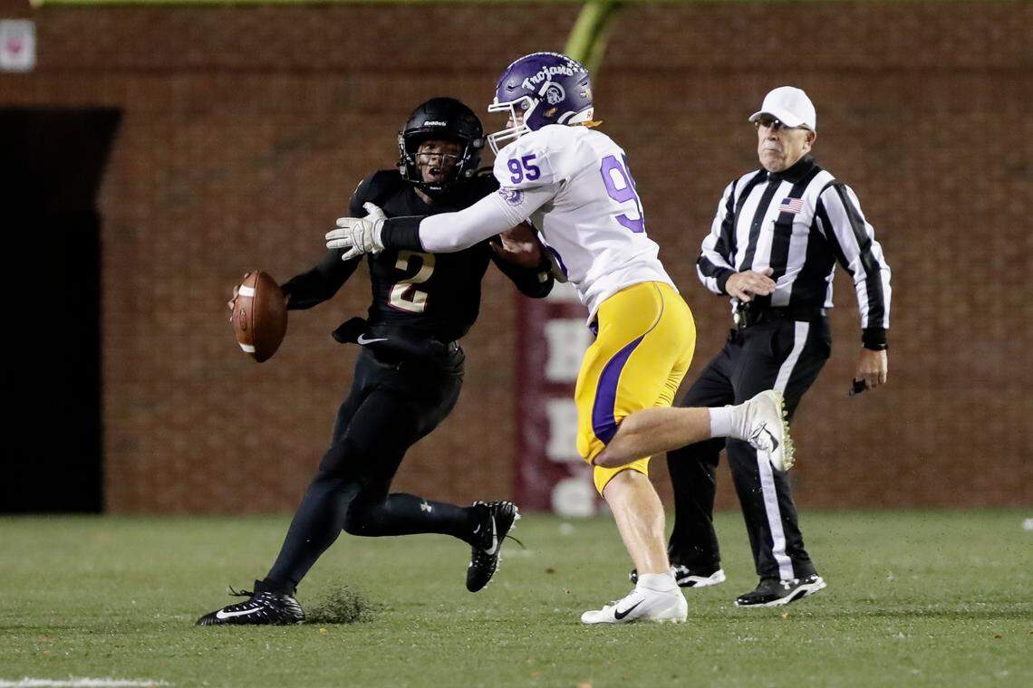 Rock Hill quarterback (2) Matthew Wilson is pressured by Northwestern’s (95) Isaac McLellan in first half playas Northwestern takes on Rock Hill in Friday night varsity football action, 10-29-2021.