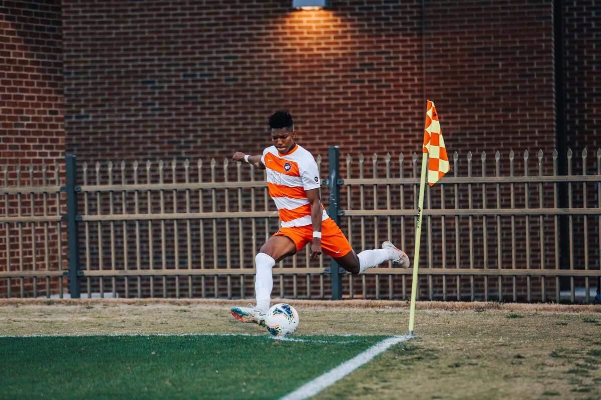 Isaiah Reid, a left-footed forward who plays on the left wing, takes a corner kick for Clemson.