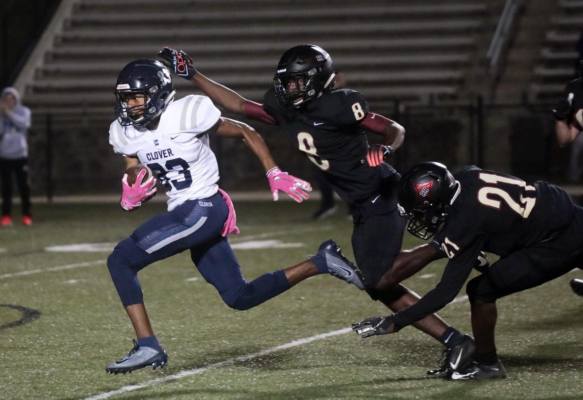 Clover’s Jaylin Lane (83) leaves behind Rock Hill’s Buck Peay (8) and Jamaris Pressley to score a touchdown in the first half of the game Friday.