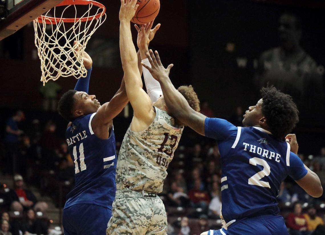 Winthrop’s Hunter Hale, center, and Asheville’s Jamon Battle (11) and L.J. Thorpe fight for control of the ball Saturday, Feb. 1, 2020 at the Winthrop Coliseum in Rock Hill, S.C.